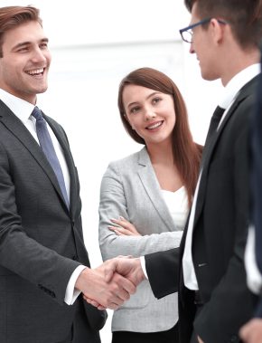 colleagues shaking hands in office.