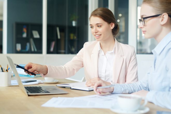 Young economist pointing at laptop display during consultation